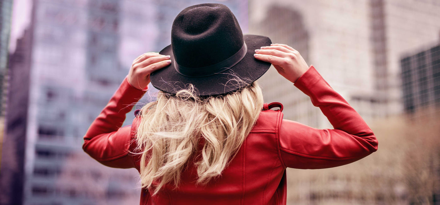 Woman with hat looks up at skyrise in San Jose CA